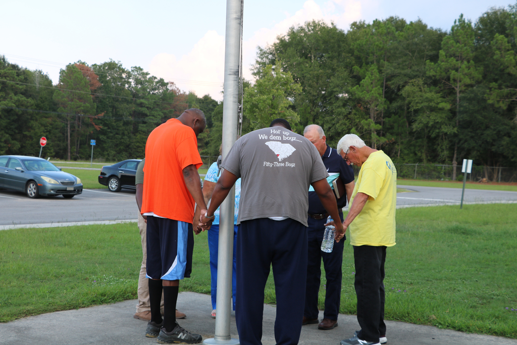 Local community and faith leaders praying at each school. 