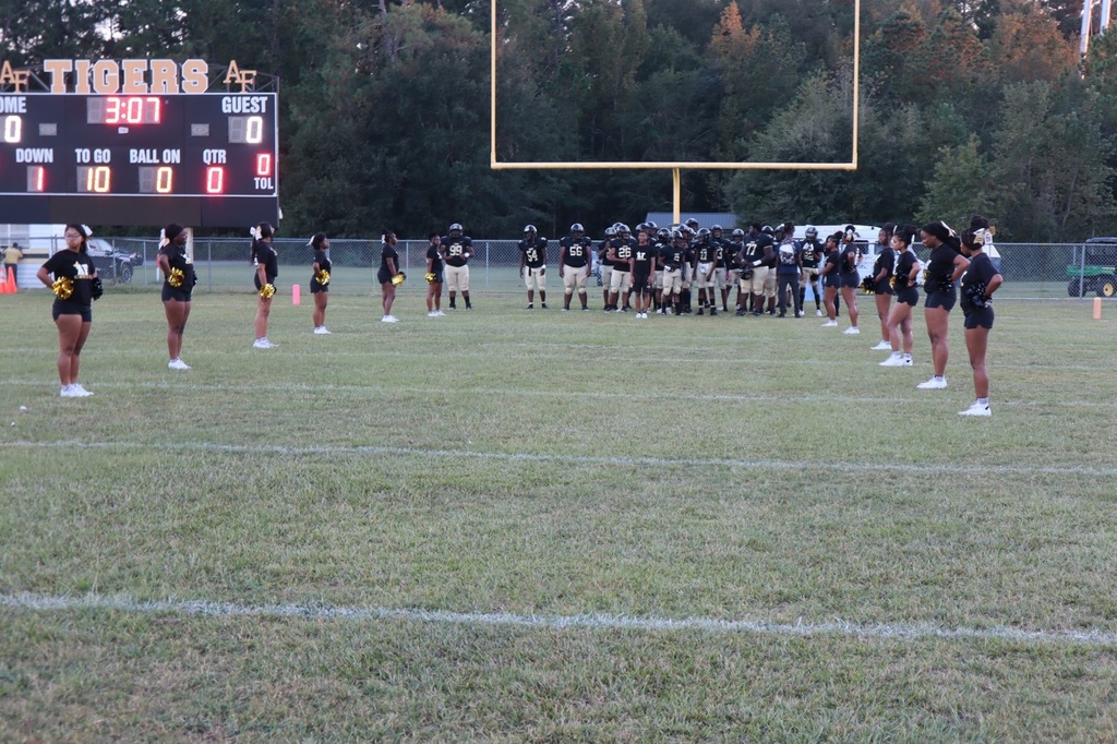 football players and cheerleaders about to run out before the game